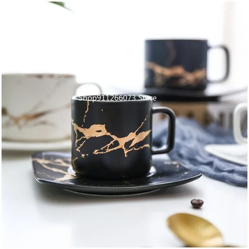 Elegant black mug about coffee with gold marbling design on a matching saucer